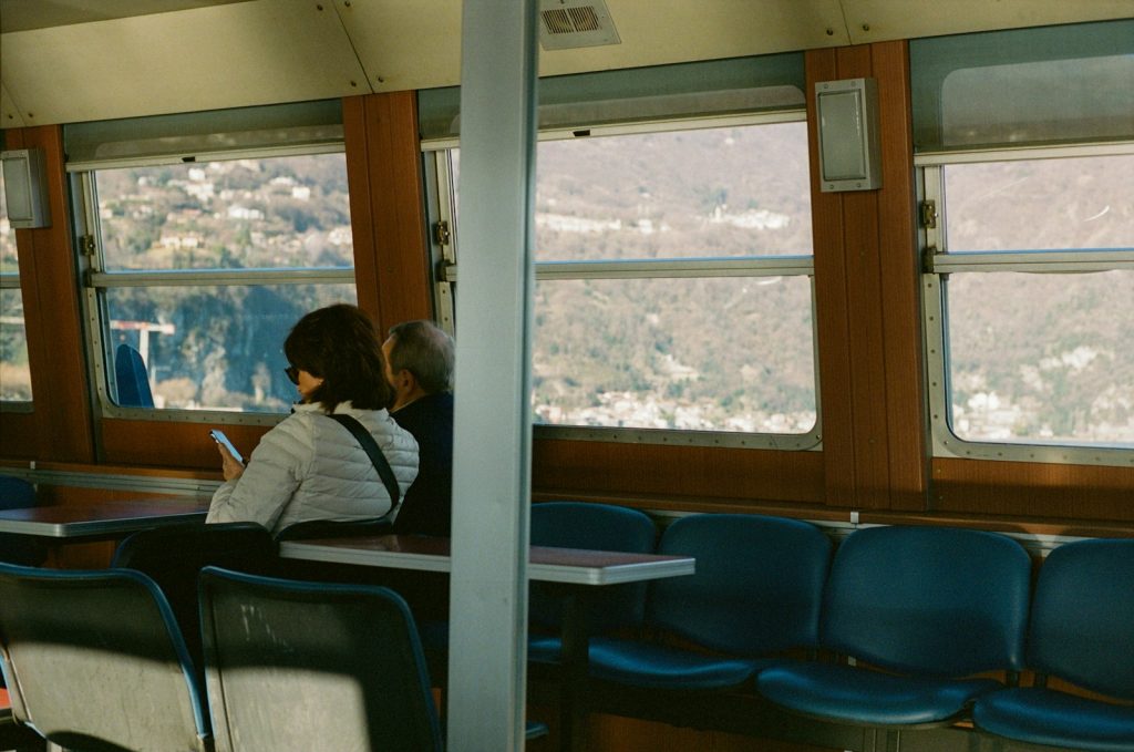 a couple of people sitting on a train next to each other