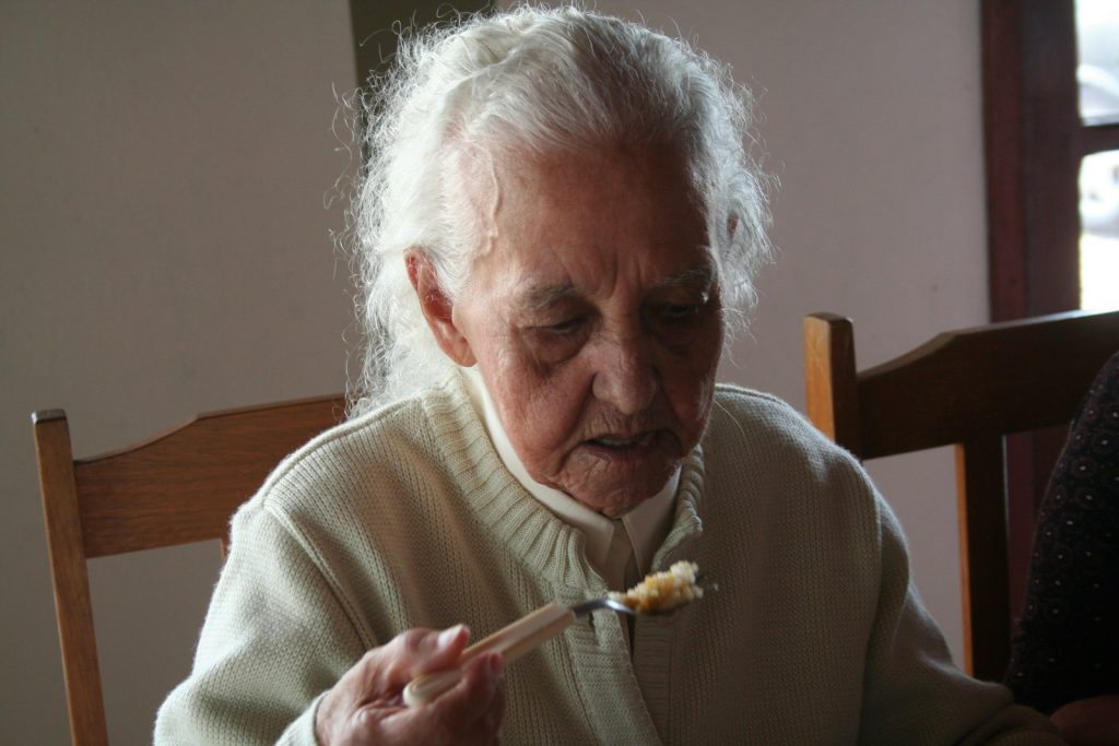 man in white sweater holding fork